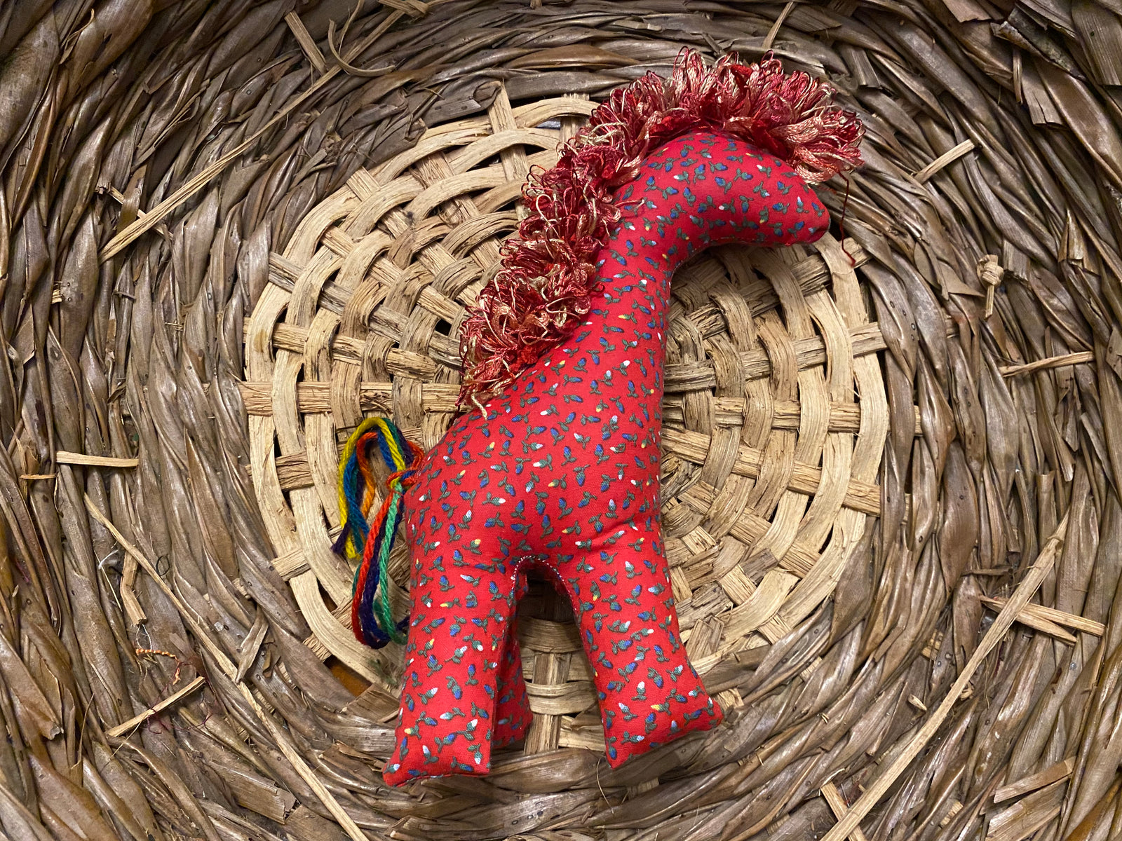 Giraffe red with small blue flowers and multi-colored mane and tail